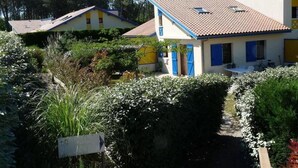 A residential area with houses featuring tiled roofs and blue shutters.