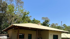 A single-story building with a tiled roof, a covered porch, and a small outdoor seating area. - Recanto da Pesca Resort (Abaeté)