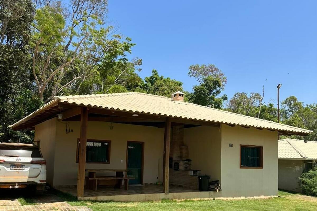 A single-story building with a tiled roof, a covered porch, and a small outdoor seating area.