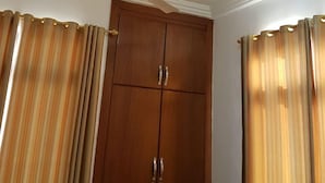 A room with a ceiling fan, wooden wardrobe, and curtains. - 2Bedrooms Private. Apart. Junction Mall (Accra)