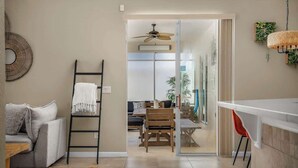A modern living room with a sofa, a ladder, a dining area with chairs, and a kitchen area with a counter and chairs. - Pool & Spa Oasis/Golf Retreat/Near Disney/3BR Home (davenport)