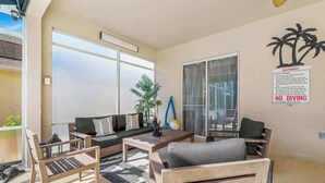 A modern living room with a sofa, chairs, a coffee table, and a poolside view. - Pool & Spa Oasis/Golf Retreat/Near Disney/3BR Home (davenport)