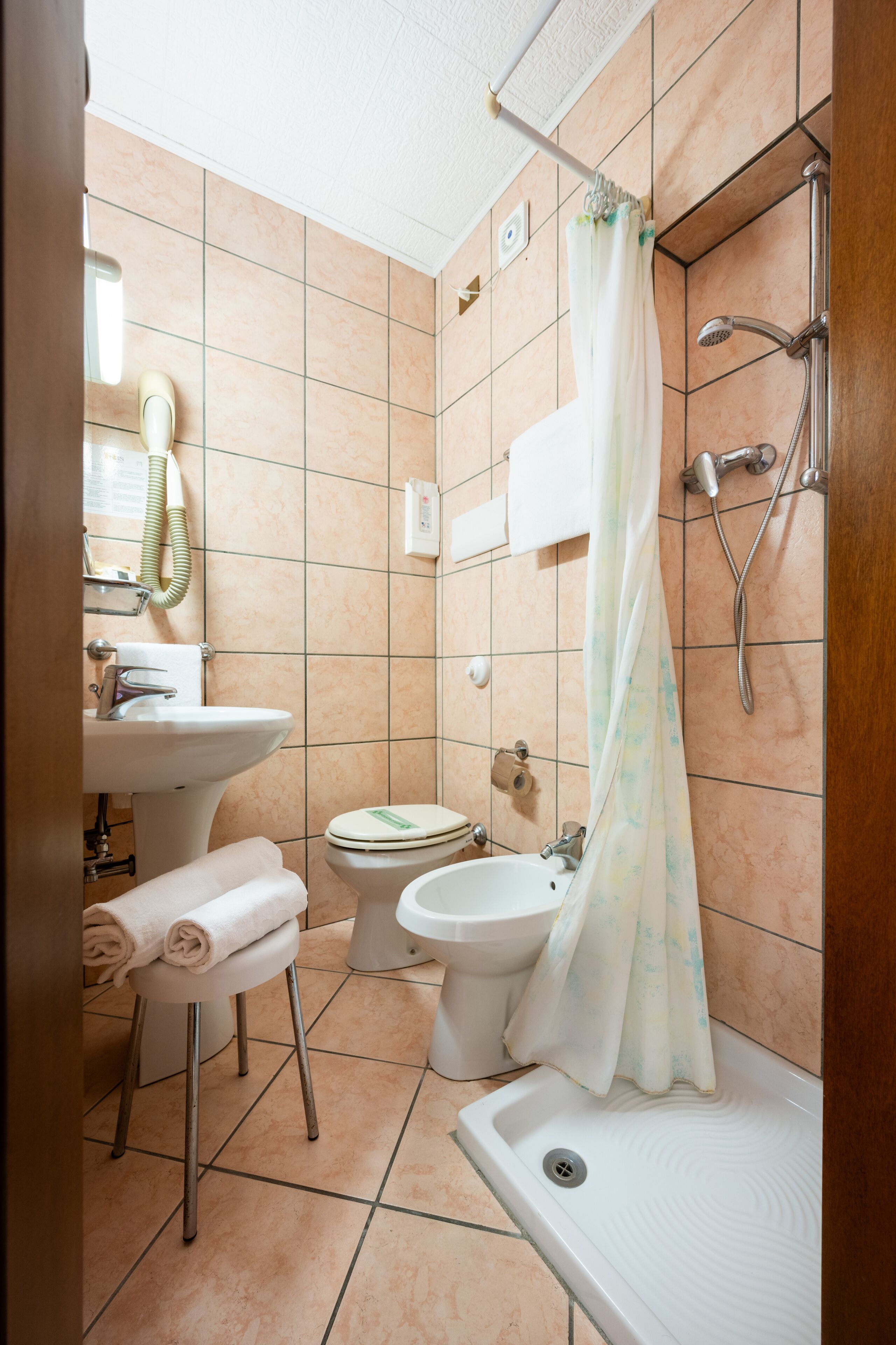 A bathroom with a sink, toilet, bidet, and bathtub.