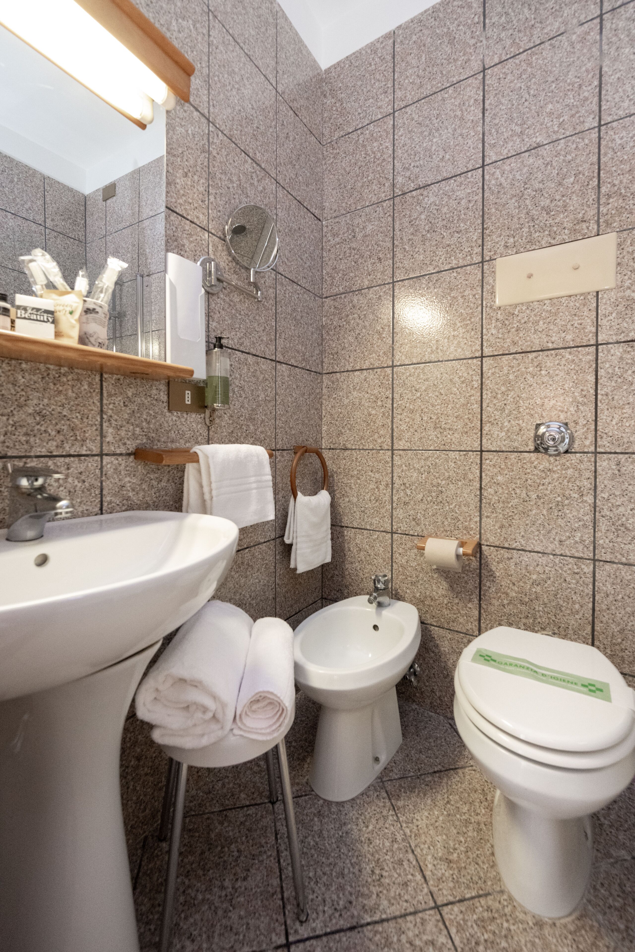 A bathroom with a sink, bidet, and toilet.