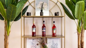 A shelf with bottles of champagne and liquor, surrounded by potted plants. - CAMELIA ROOMS VENICE GUESTHOUSE (Mestre)