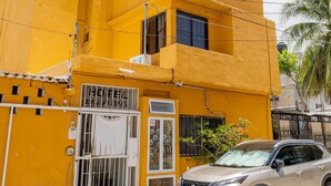 Un immeuble jaune avec une enseigne sur laquelle on peut lire « HÔTEL LAS PALMAS ».
