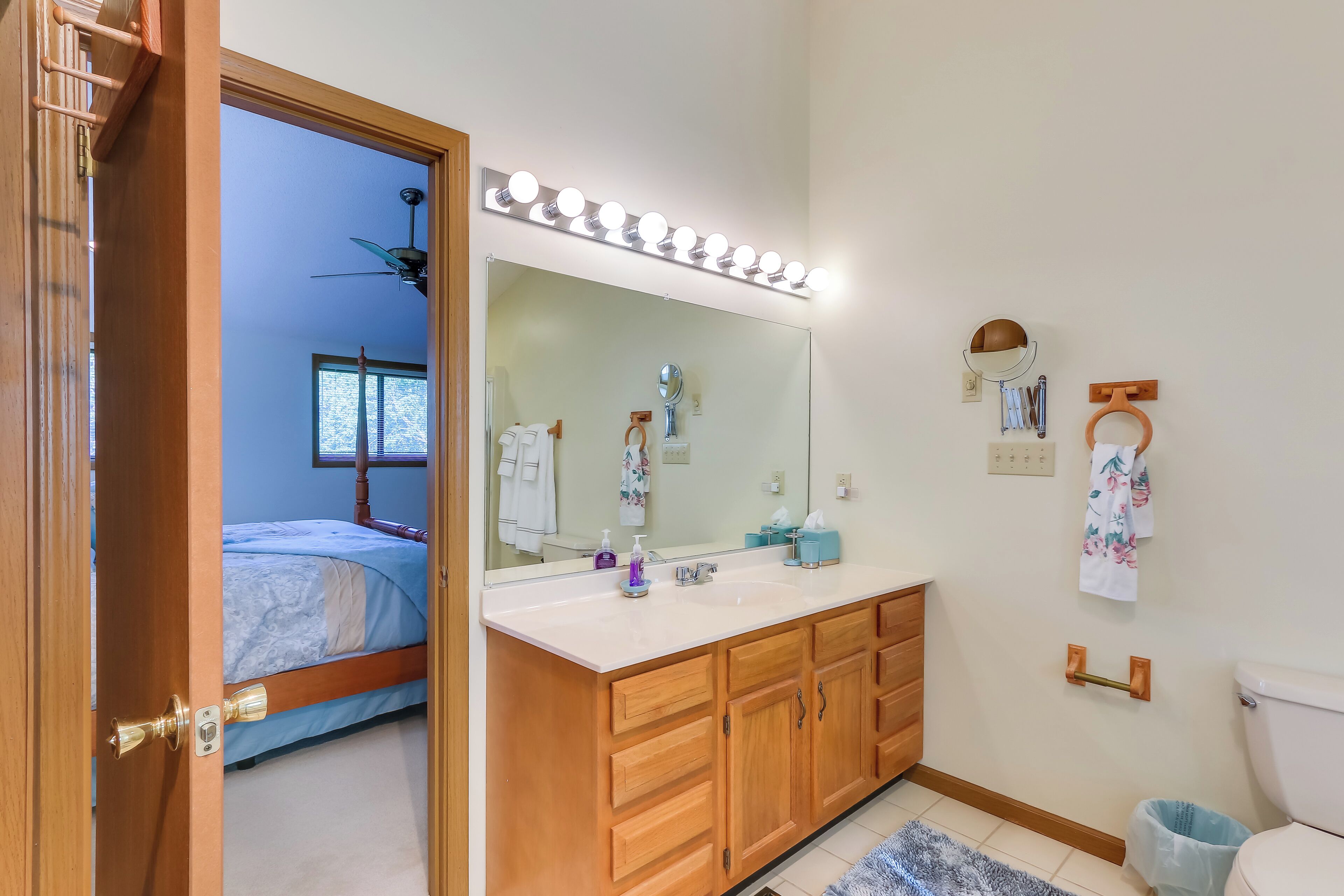 A bathroom with a vanity, mirror, and toilet.