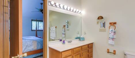 A bathroom with a vanity, mirror, and toilet.