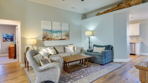 A living room with a sofa set, a coffee table, a patterned rug, and a painting on the wall. - Family-friendly PCB Vacation Rental, Walk to Beach (Panama City Beach)