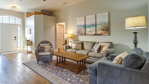 A living room with a wooden coffee table, grey sofa, and a patterned rug. - Family-friendly PCB Vacation Rental, Walk to Beach (Panama City Beach)