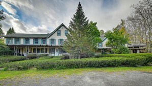 Une grande maison à deux étages, dotée d’un porche et d’une pelouse bien entretenue.