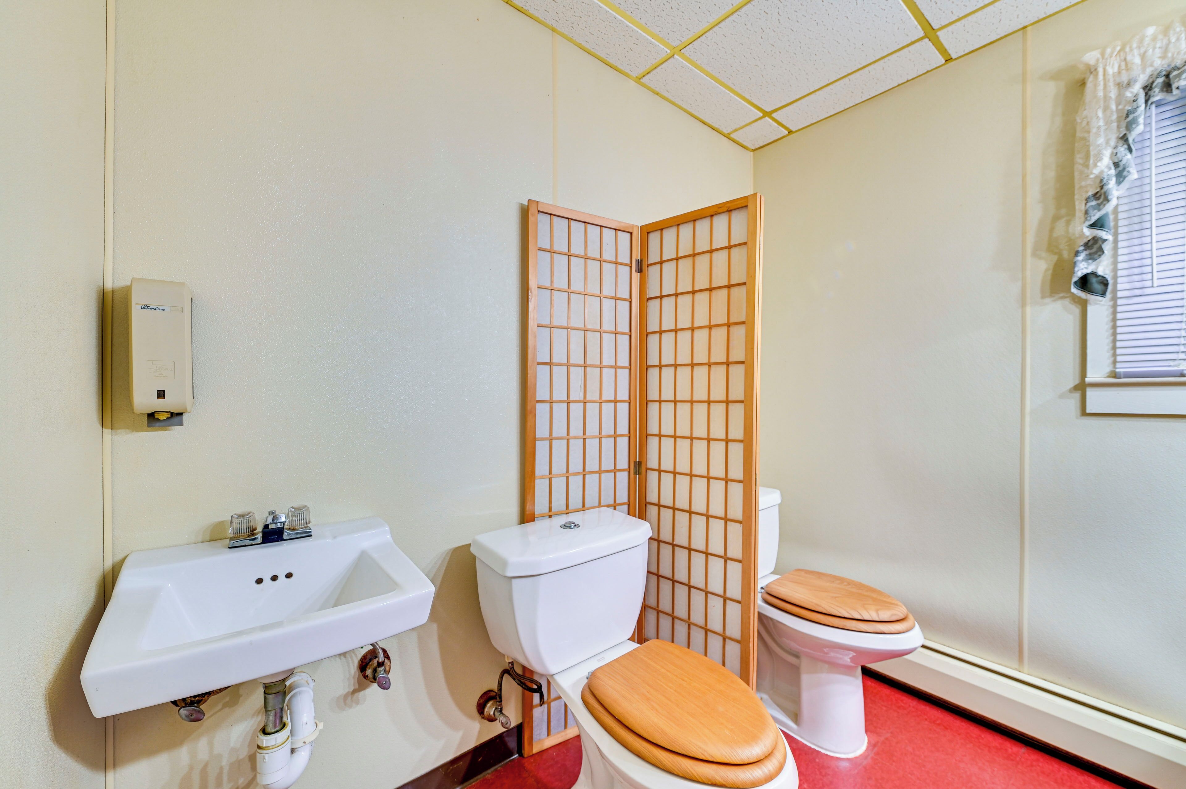 Ein Badezimmer mit Waschbecken, Toilette und einer Holzwand.