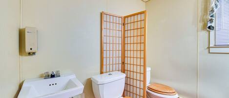 Ein Badezimmer mit Waschbecken, Toilette und einer Holzwand.