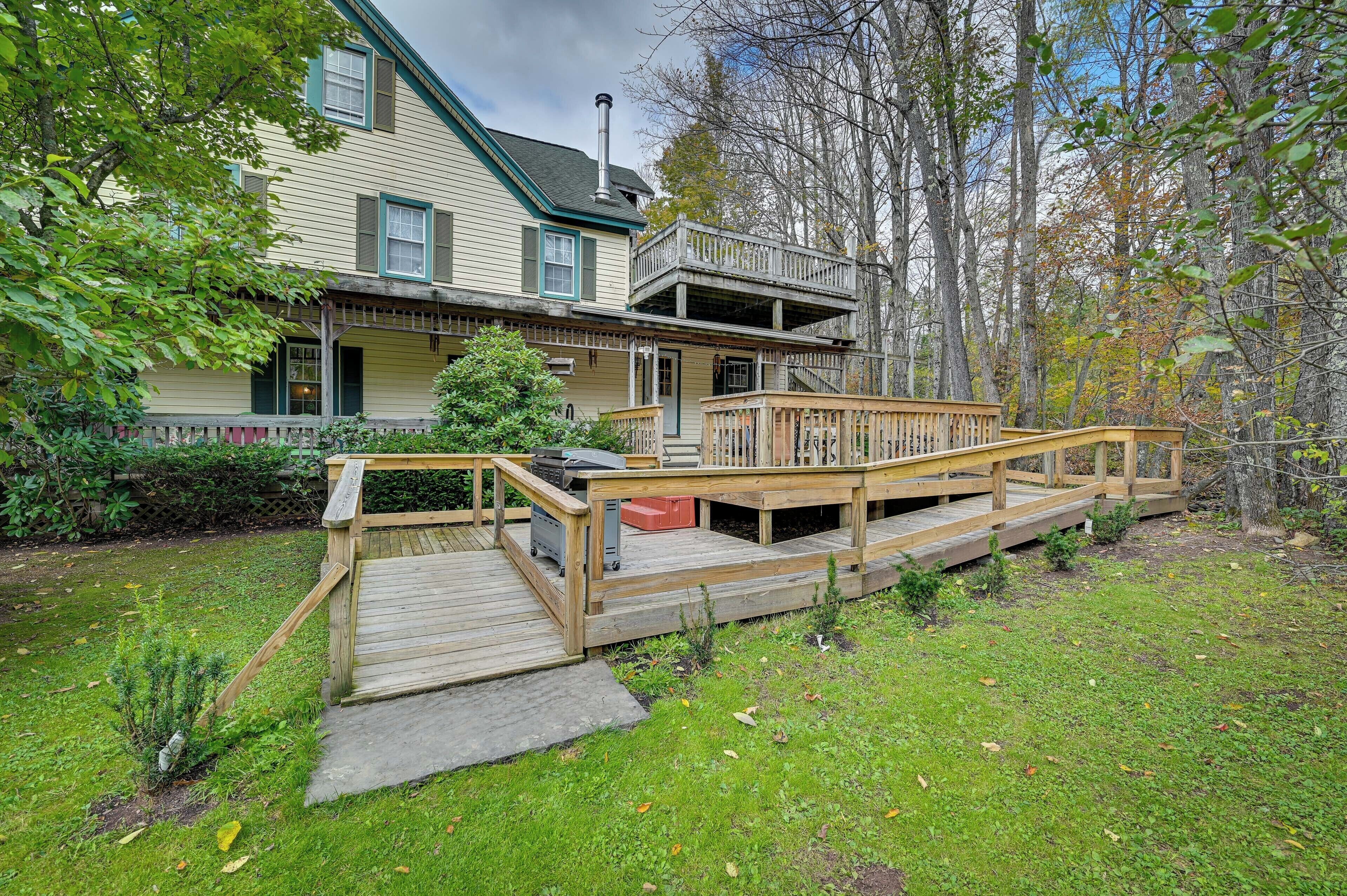 A two-story house with a wooden deck and a covered porch.