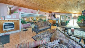 Un salon chaleureux avec un plancher en bois, une cheminée et divers meubles, notamment des canapés et une table basse.