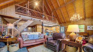 A spacious living room with a high ceiling, a staircase to an upper level, and a cozy fireplace. - Robbinsville Vacation Rental w/ Covered Balcony (Robbinsville)
