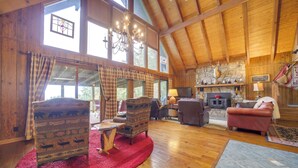 A spacious wooden interior with high ceilings, large windows, and a fireplace. - Robbinsville Vacation Rental w/ Covered Balcony (Robbinsville)