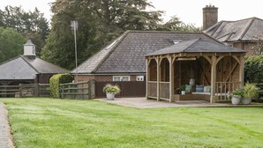 A brick house with a wooden gazebo in the yard.