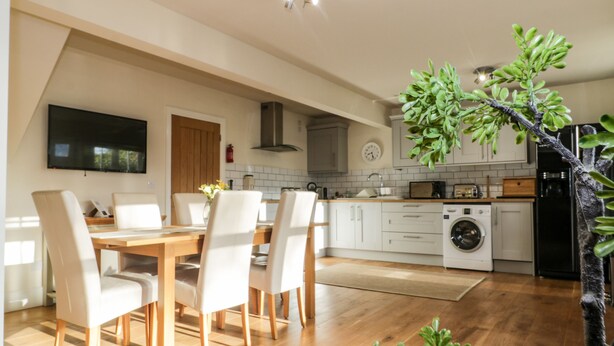 A modern kitchen with white cabinets, a built-in oven, and a washing machine.