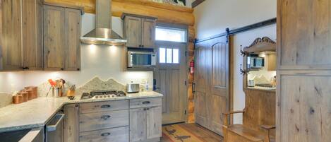 Una cocina con gabinetes de madera, un microondas y una estufa.
