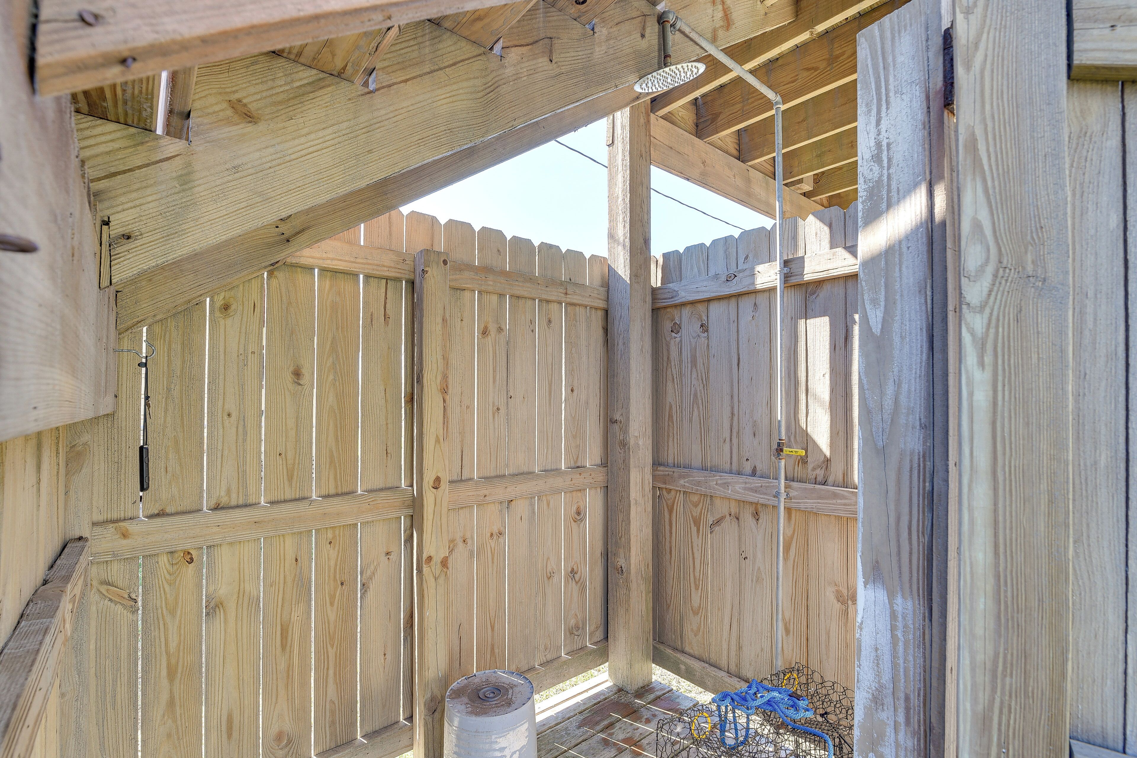 Une structure en bois dotée d’un toit en pente et d’une clôture en bois.