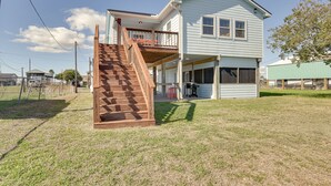 A two-story house with a wooden staircase leading to a balcony. - Waterfront Sargent Home w/ Kayaks & Boat Dock! (Bay City)
