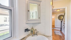 A bathroom with a white sink, a mirror, and a window. - Lovely Westerley Home w/ Yard & Grill! (Westerly)