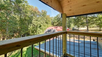 Enjoy a serene view from the deck, surrounded by lush greenery and a yard.