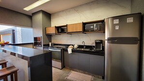 Une cuisine moderne dotée d’un îlot central, d’appareils électroménagers en acier inoxydable et de meubles en bois.