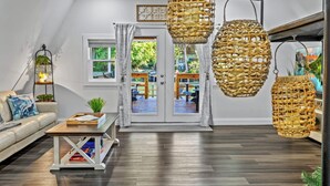 A modern living room with a sofa, coffee table, and hanging wicker lamps. - Weeki Wachee Waterfront-A Frame Stream Dream Cabin (Spring Hill)