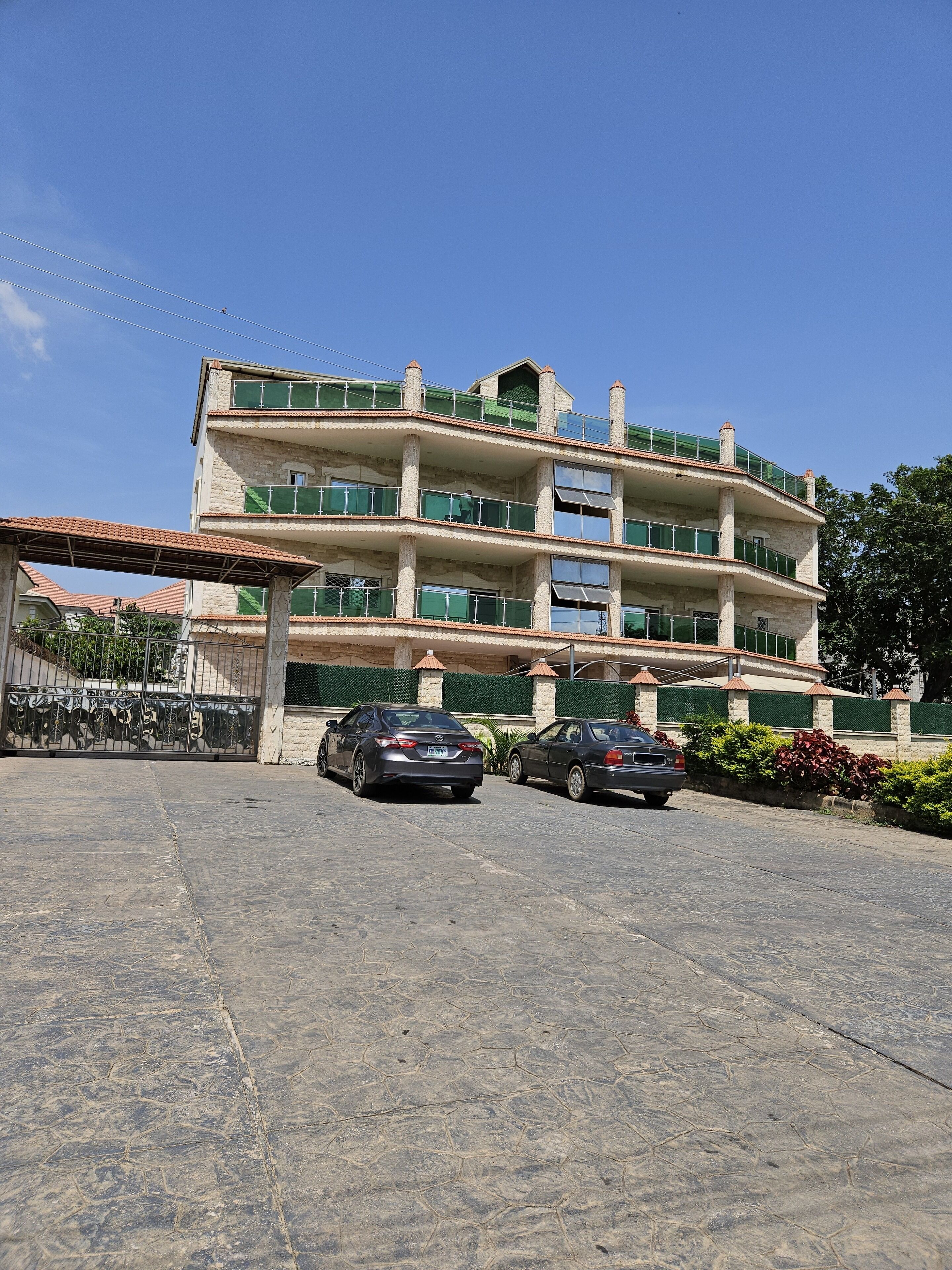 A multi-story building with a parking area in front.