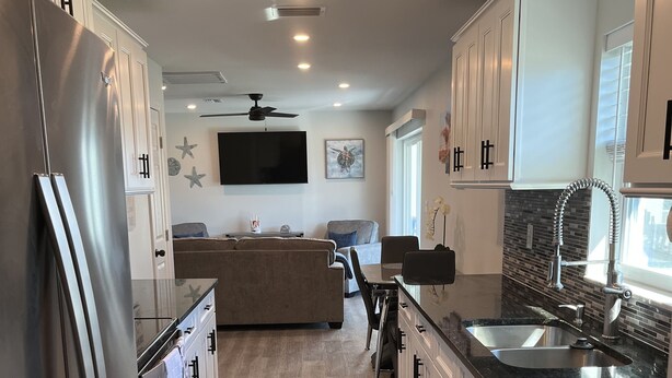 A modern kitchen with a central island, built-in appliances, and a dining area with a sofa and chairs.