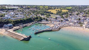 An aerial view of Brynawelon, featuring a marina, beach, and surrounding residential area.