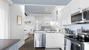 A modern kitchen with white cabinetry, stainless steel appliances, and a central island. - Linkside Court 21 - Community Tennis/Pickleball! (Isle of Palms)