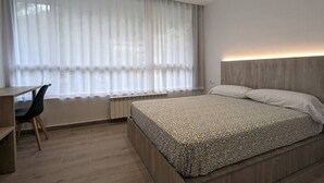 A modern bedroom with a bed, a desk, and a chair. - Hydros Ter Ripoll HUT (Ripoll)