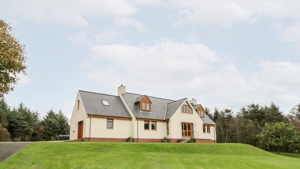 A large, single-story house with a sloped roof and a well-maintained lawn in front. - Cairnhapple House (Stranraer)
