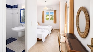 A hotel room with a bathroom, a bed, a desk, and a window with a view. - Villa Thalia Katerina (Mousata)
