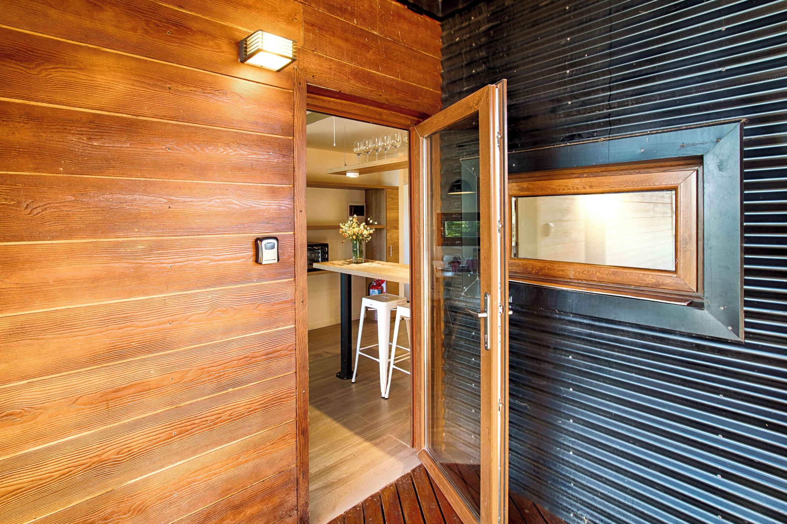 Interior de madeira com uma porta que dá para uma cozinha.