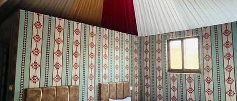 Une chambre avec deux lits, un papier peint à motifs et un décor de plafond original.