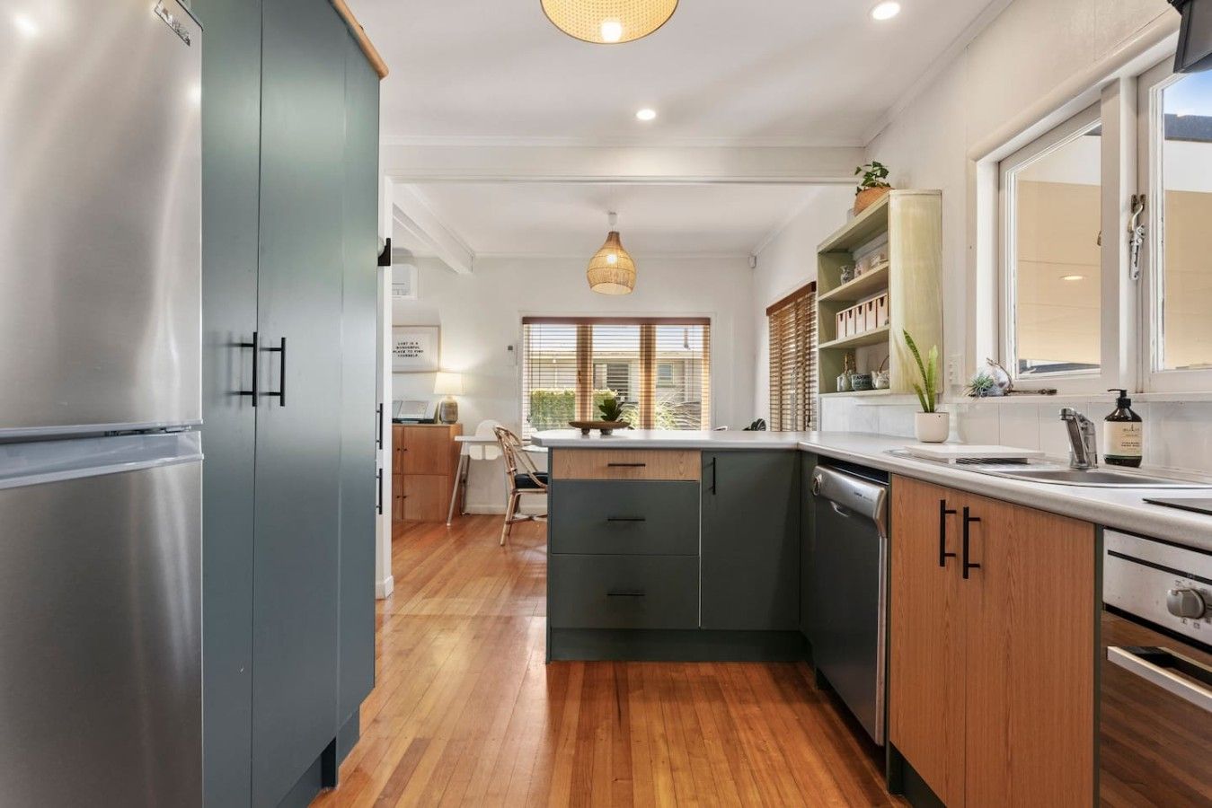 A modern kitchen with stainless steel appliances, wooden cabinets, and a central island.