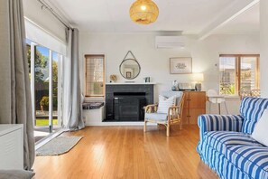 Una sala de estar moderna con chimenea, un sofá, una silla y un comedor.
