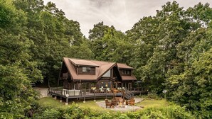 Une cabane dotée d’une terrasse, entourée d’une forêt dense.