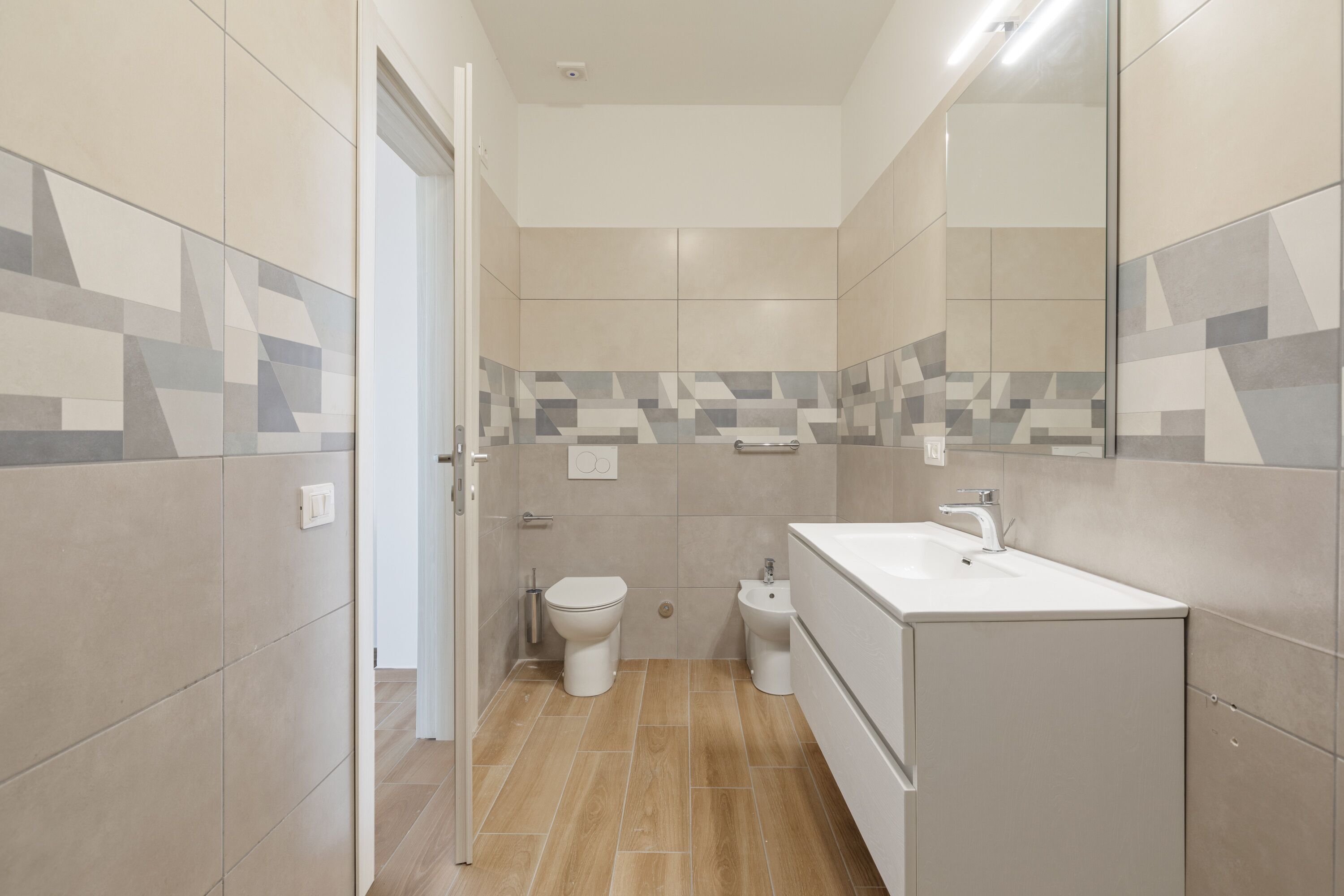 A modern bathroom with a toilet, bidet, and sink.