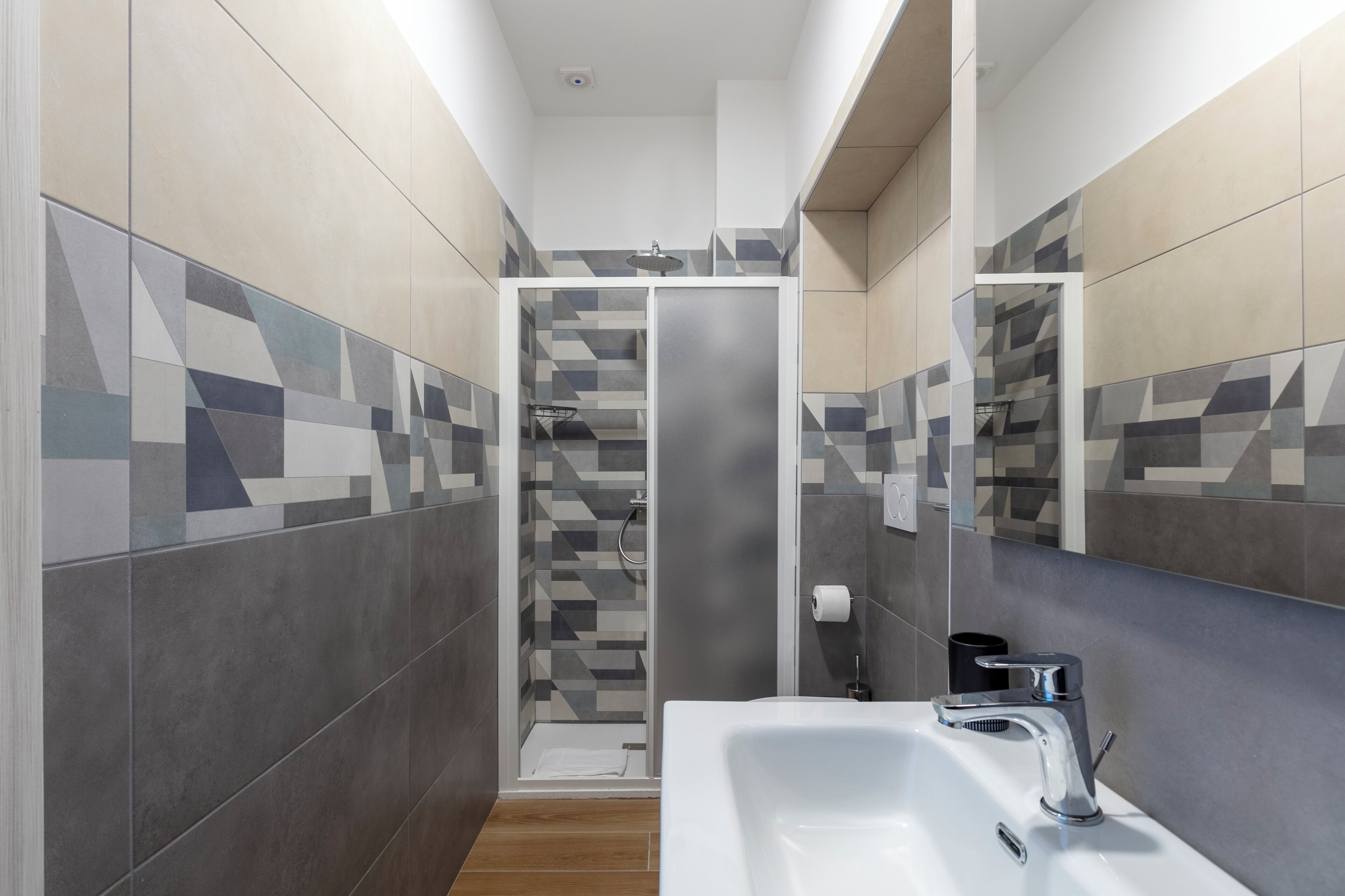 A modern bathroom with a shower, a sink, and a mirror.