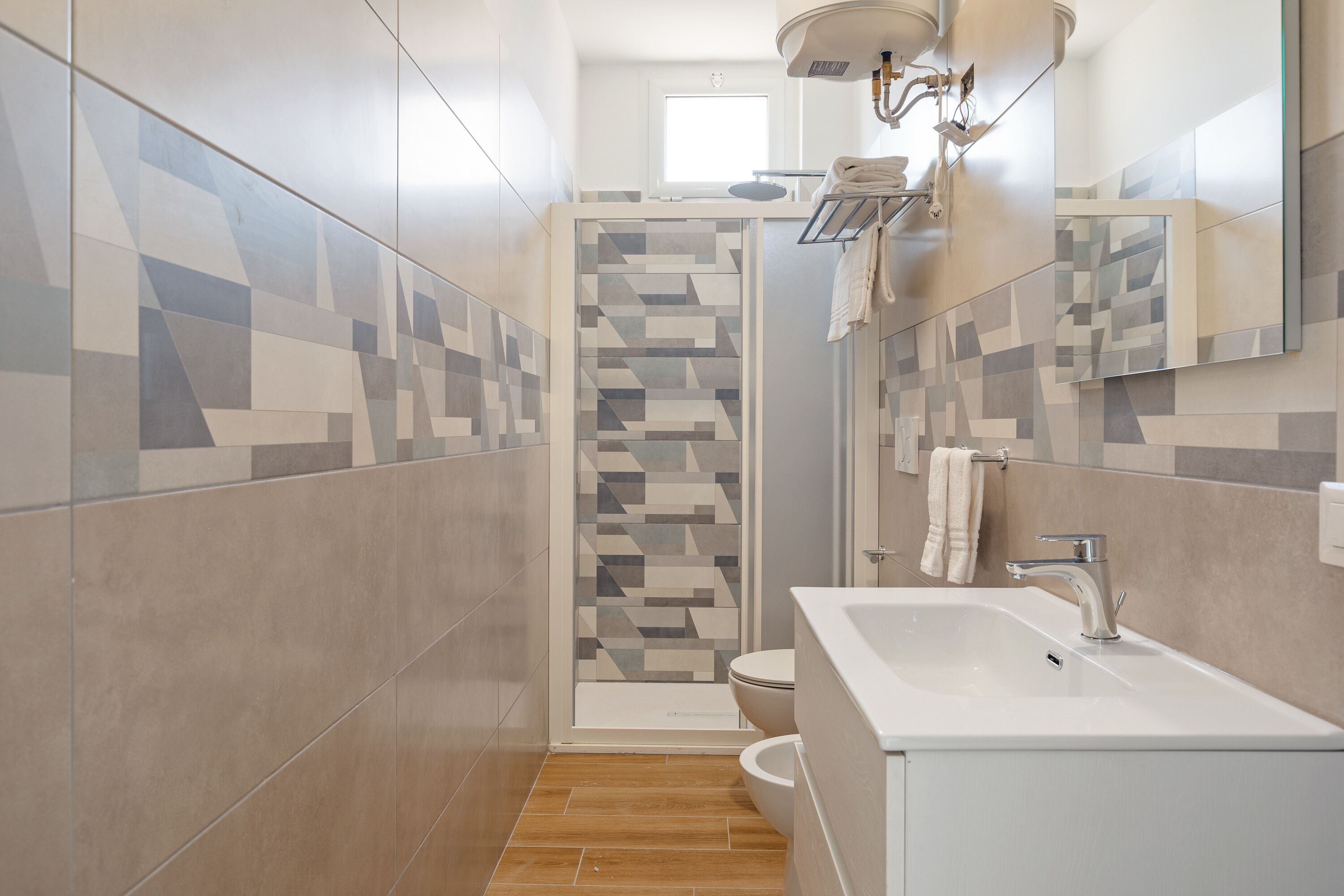 Un baño moderno con ducha, inodoro y lavabo.