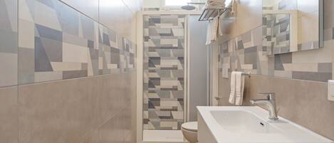Un baño moderno con ducha, inodoro y lavabo.