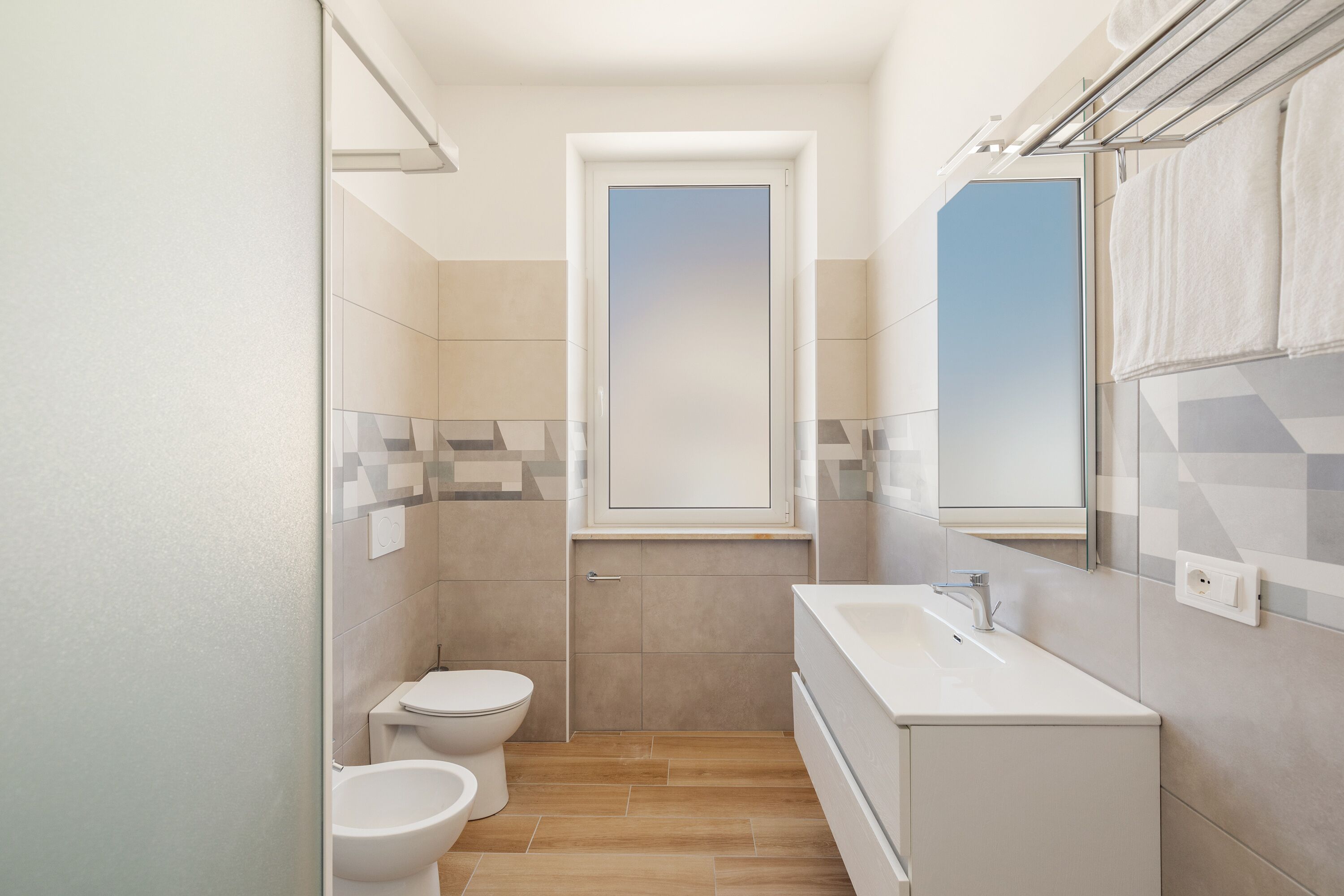 A modern bathroom with a toilet, bidet, and a sink.