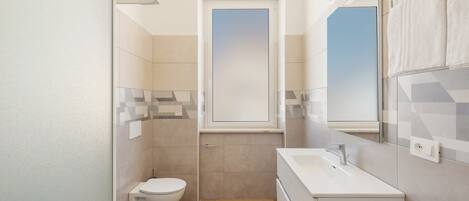 A modern bathroom with a toilet, bidet, and a sink.