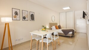 Una habitación moderna con una mesa de comedor, sillas, cama y televisor.