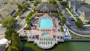 An aerial view of a hotel with a central swimming pool, a dock, and a parking area. - Cozy 3 Bedroom Villa Near Disney (Kissimmee)
